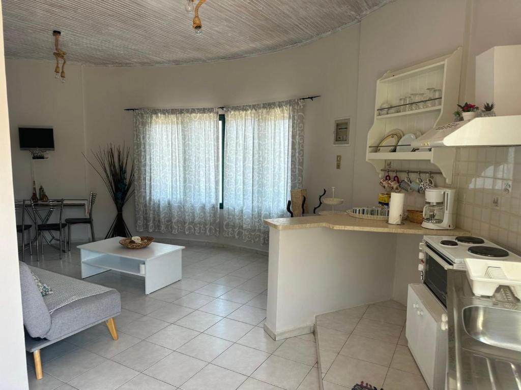 una cucina e un soggiorno con piano cottura e tavolo di Razos Windmill a Vathi