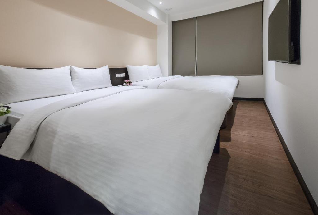 1 cama blanca grande en una habitación de hotel en 橙柊棧 CZ Inn, en Taipéi
