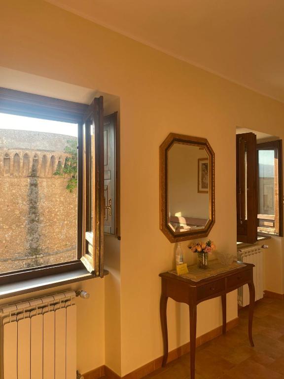 a room with a mirror and a table and a window at La rosa del castello in Castrovillari
