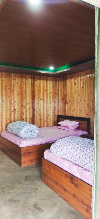 two bunk beds in a room with wooden walls at Zero Points TheLaure Cottage in Ilām