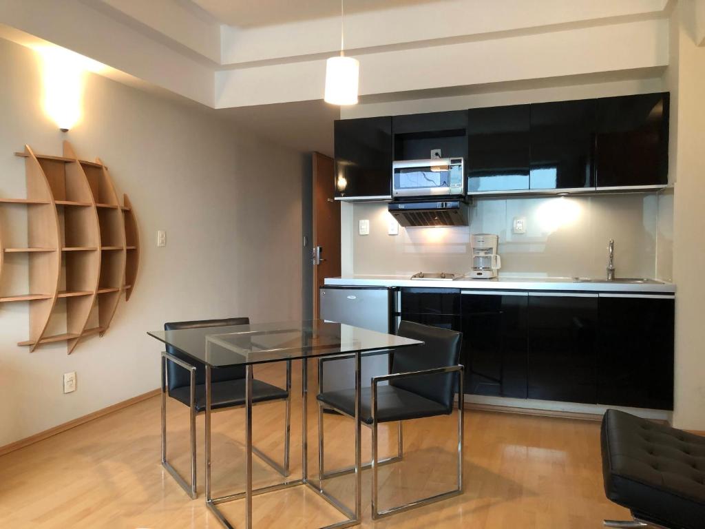 A bright kitchenette and four-seat dining area with open shelving.