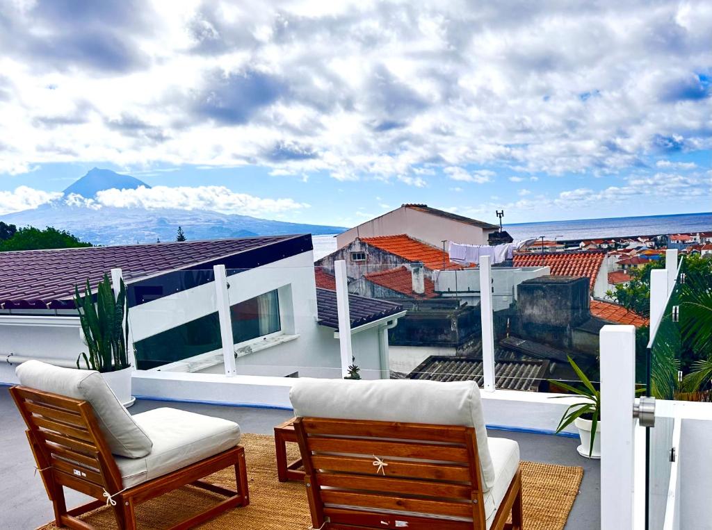 a balcony with a couch and chairs on a roof at UpTown Apartments in Horta