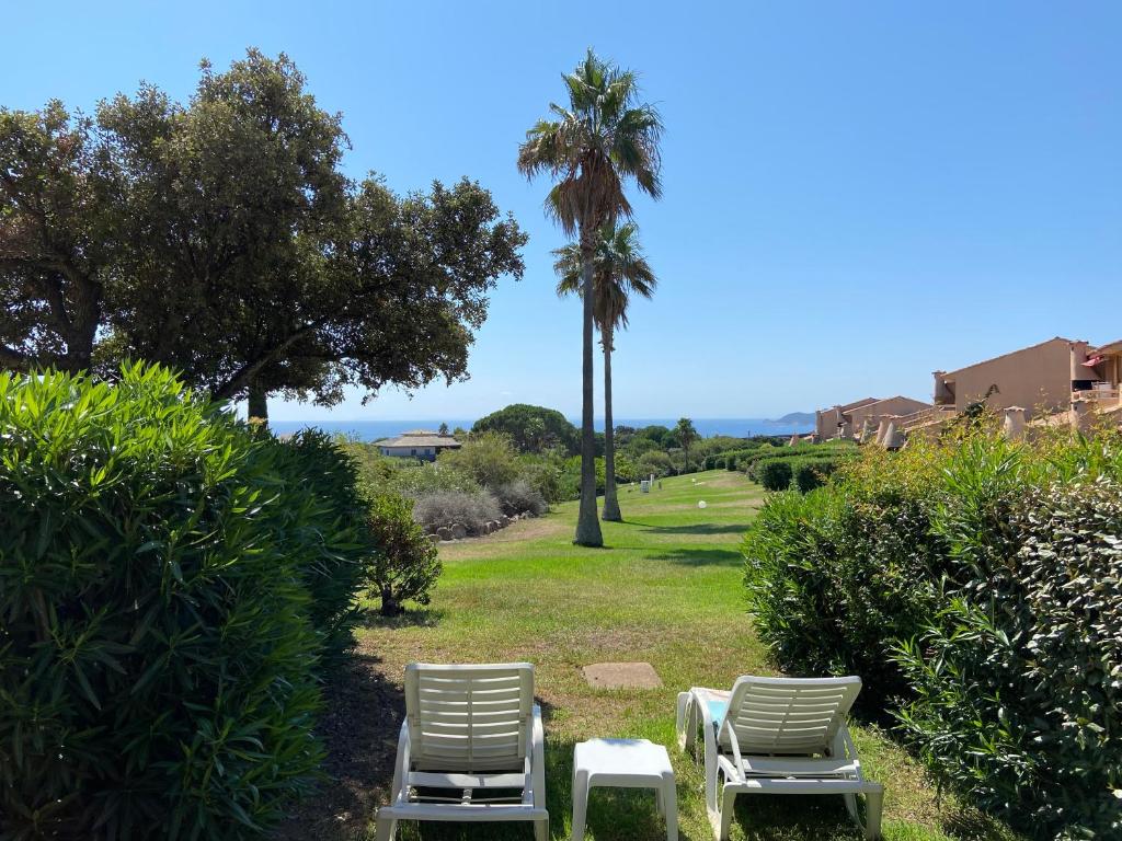 due sedie a sdraio e una palma in un parco di Mini-villa Bocca del Oro - Sud Porto-Vecchio a Bocca del Oro