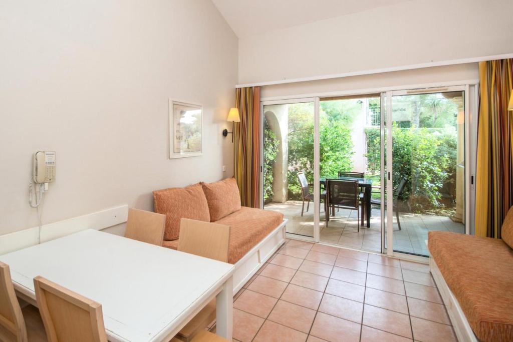 un salon avec un canapé et une table dans l'établissement Résidence Le Hameau de la Pinède - maeva Home - Studio 5 Personnes climatisé - Sélection MAE-0844, à Hyères