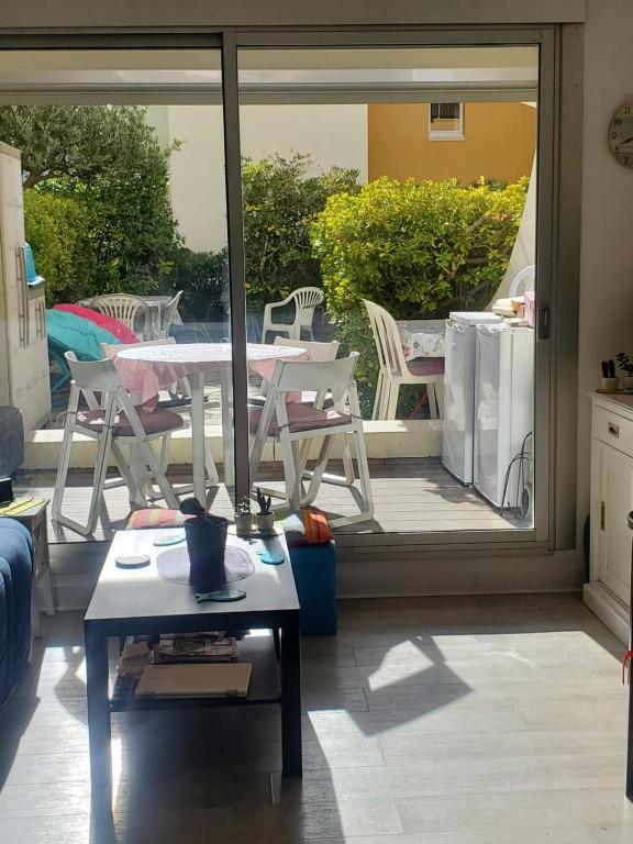 d'un salon avec une table et une porte coulissante en verre. dans l'établissement Appartement studio bord de mer, au Cap d'Agde
