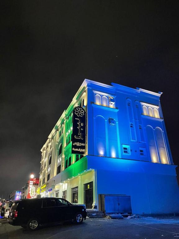 a blue building with a car parked in front of it at ليبرا سويتس - Libra Suites in Khamis Mushayt