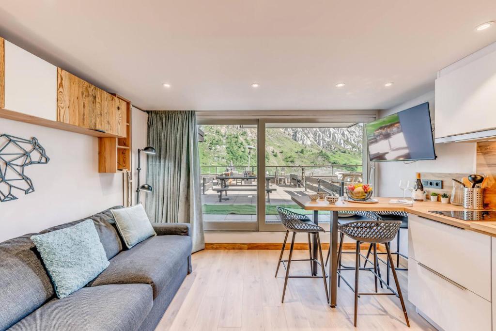 un salon avec un canapé, une table et des chaises dans l'établissement Résidence Palafour - Studio chaleureux, terrasse vue lac MAE-3398, à Tignes