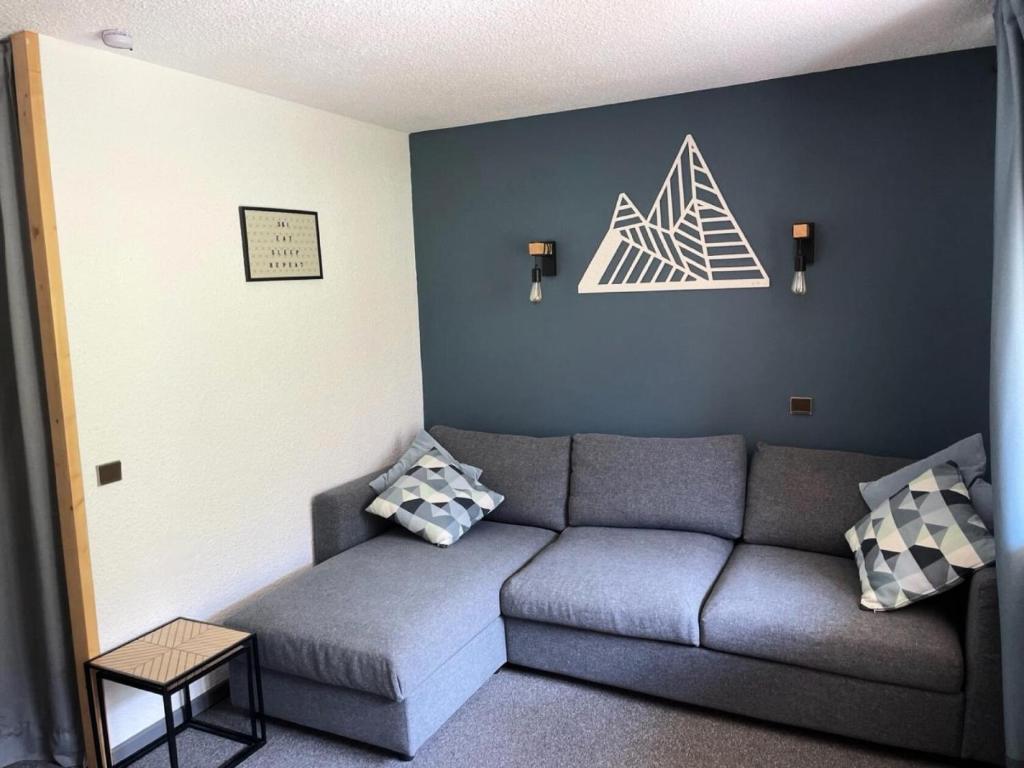 - un salon avec un canapé gris dans l'établissement Résidence Amethyste - Studio pour 4 Personnes 47, à Mâcot La Plagne
