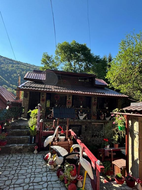ein Gebäude mit einem Tisch und Stühlen davor in der Unterkunft Vila Movilă in Azuga