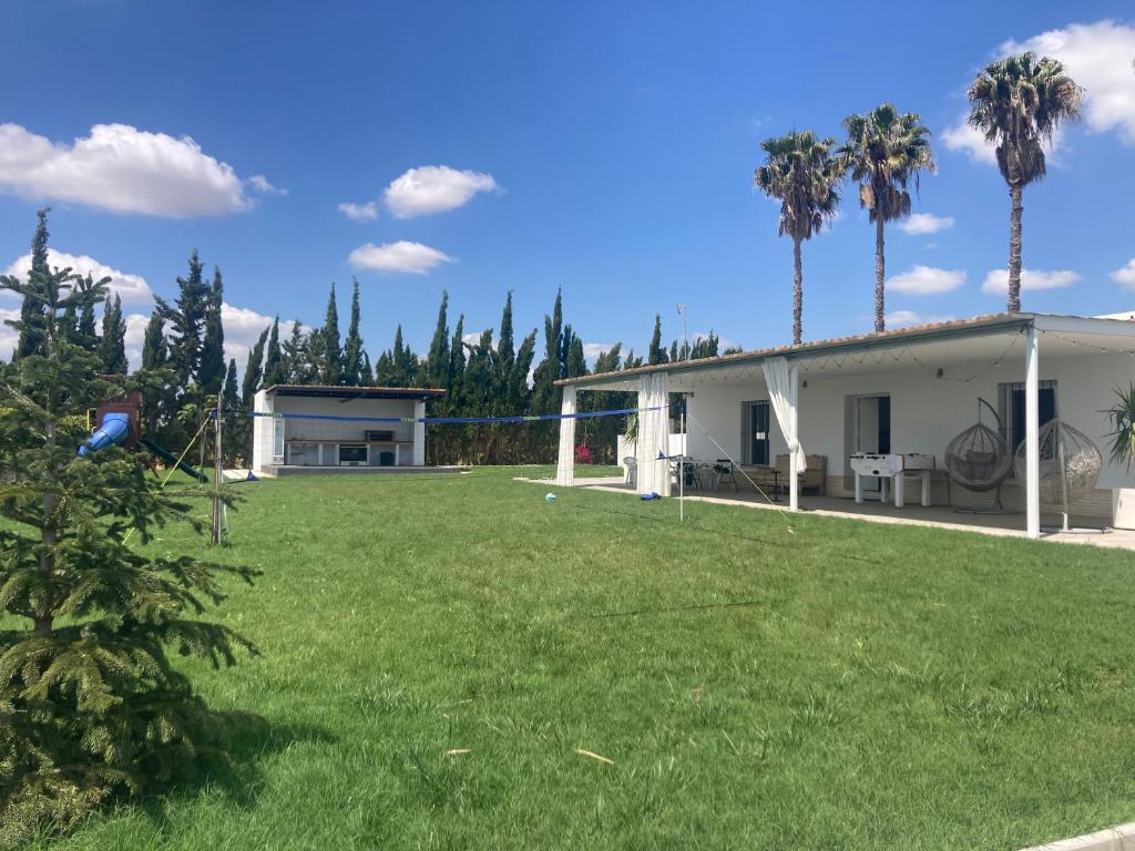 a house with a large yard next to a house at Casa rural , campo ocio, eventos, Villa Rural in Dos Hermanas