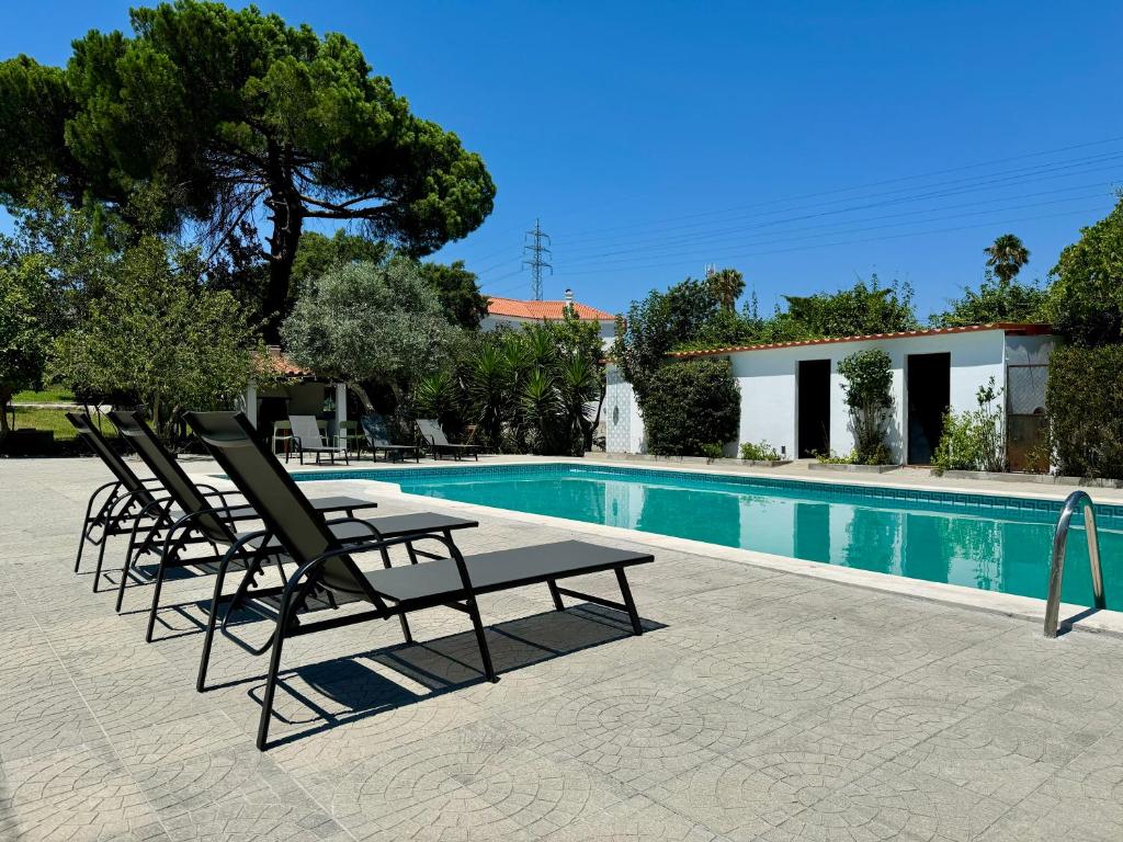 a group of lounge chairs next to a swimming pool at Portuguese Luxury Villa in Setúbal