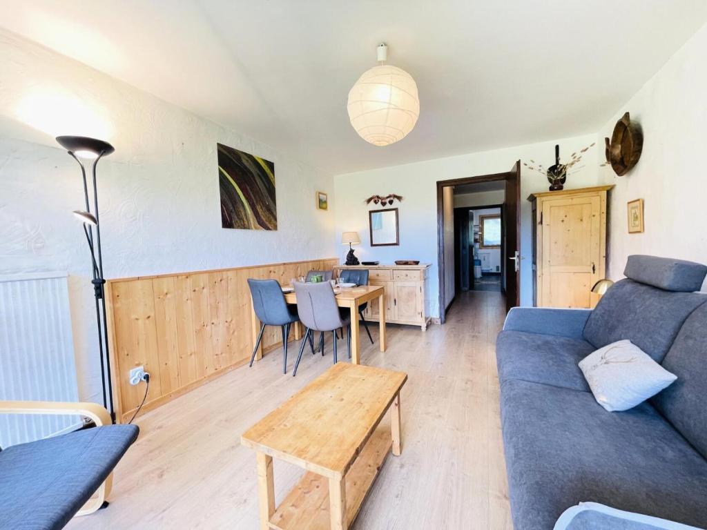un salon avec un canapé bleu et une table dans l'établissement Résidence Les Mousquetaires - Appartement cosy skis aux pieds MAE-2544, à Notre-Dame-de-Bellecombe