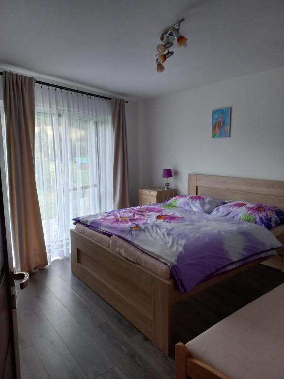 JasenicaChatka Katka的一间卧室配有一张带紫色床单的床和窗户。