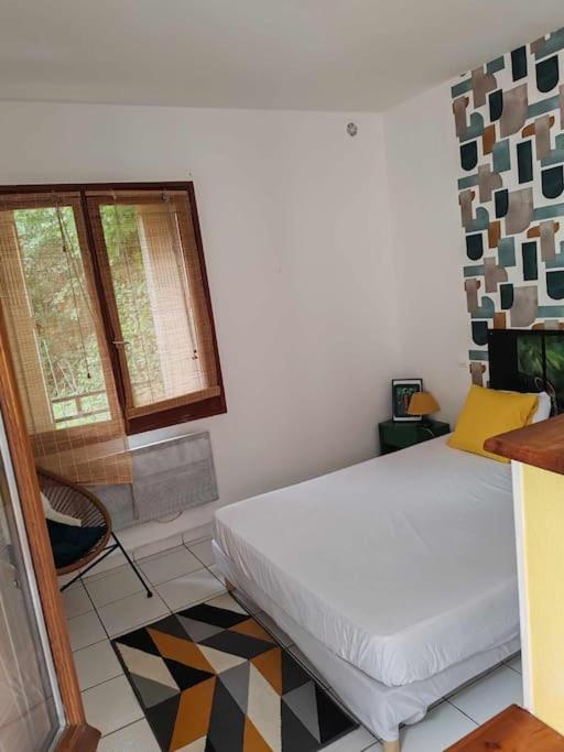 une chambre avec un lit blanc et une fenêtre dans l'établissement or rose, à Toulouse