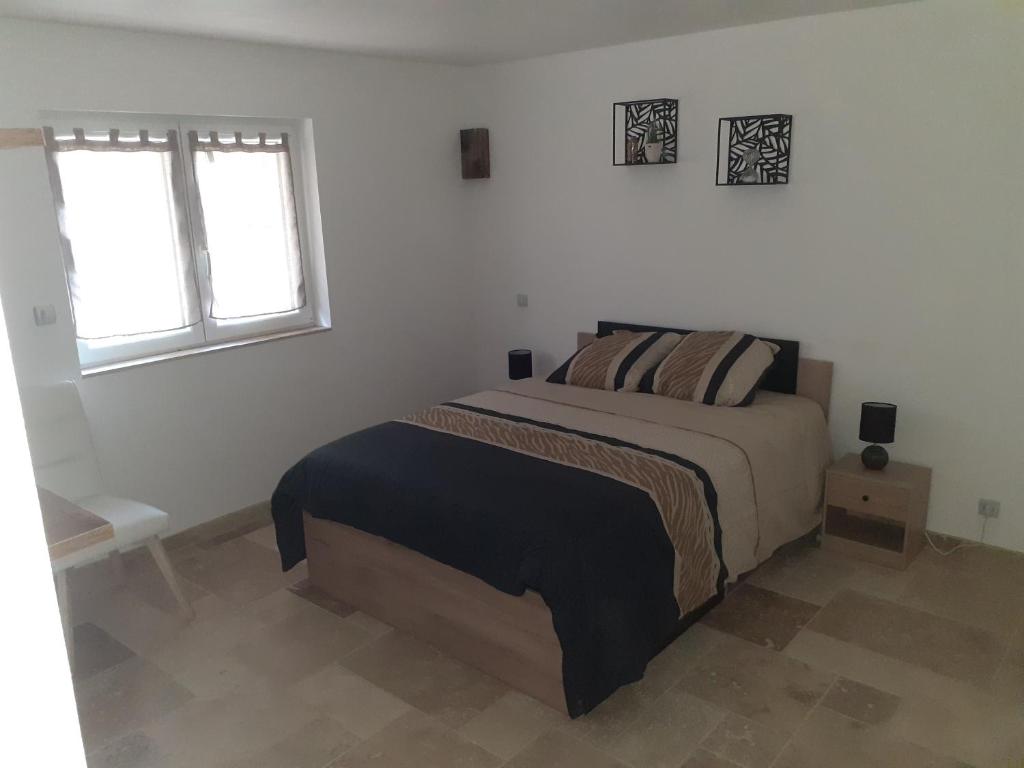 une chambre avec un lit et une fenêtre dans l'établissement Maison Périgord, à Saint-Cernin-de-lʼHerm