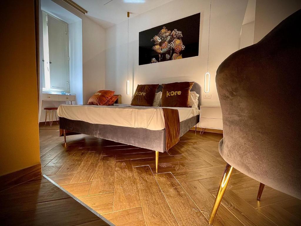 a bedroom with a bed and a chair in it at Kore Suite Napoli in Naples