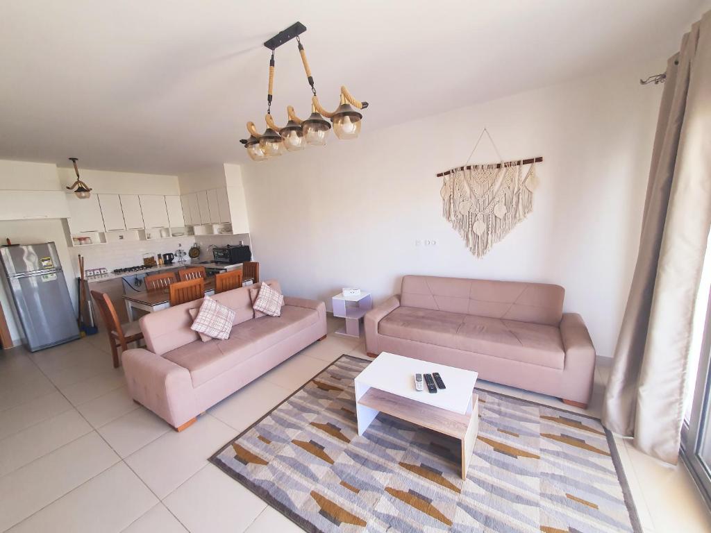 a living room with two couches and a table at شاليه فى مراسى الساحل الشمالى مارينا 2 in El Alamein