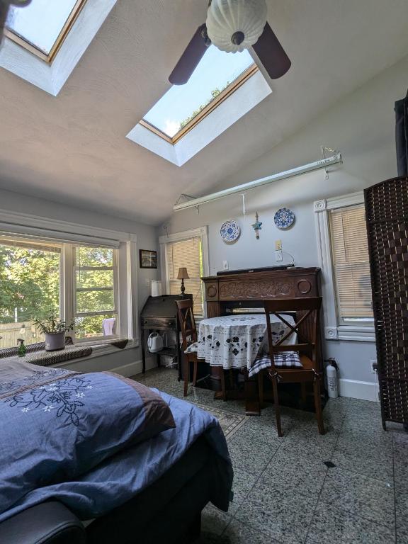 a bedroom with a bed and a table and a ceiling fan at Large Suite w/ Private Bath,great location in Boston