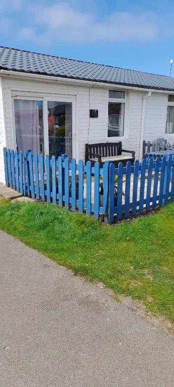 ein blauer Zaun vor einem Haus in der Unterkunft 83A South Shore Village in Bridlington