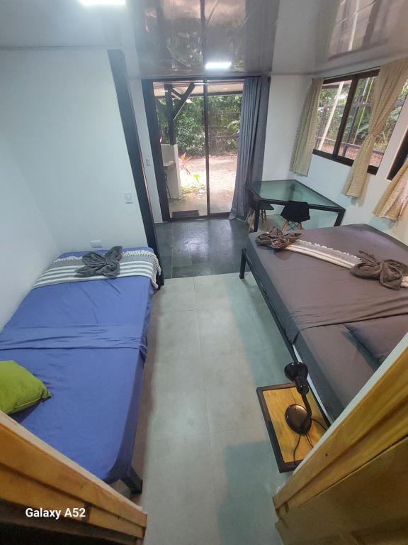 a room with two beds and a table in it at Jungle AC Suite for 3-Kitchen-Walk to Playa Chiquita -Villa Toronto in Cocles
