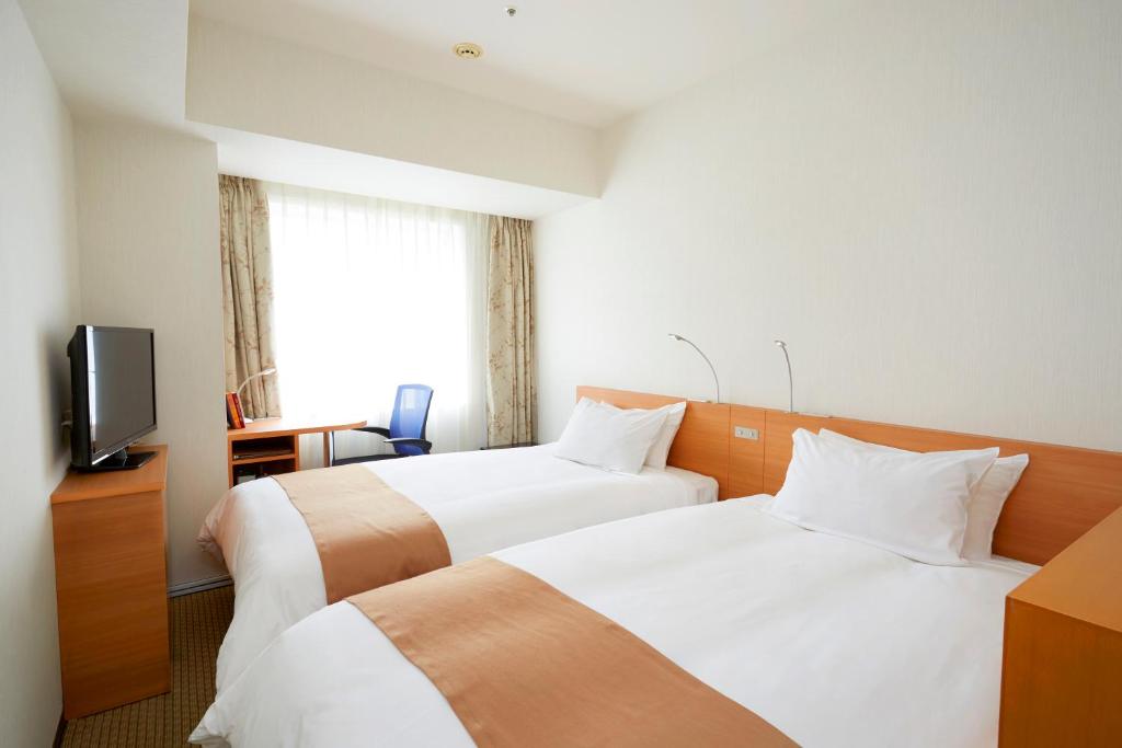 Postel nebo postele na pokoji v ubytování Keisei Hotel Miramare