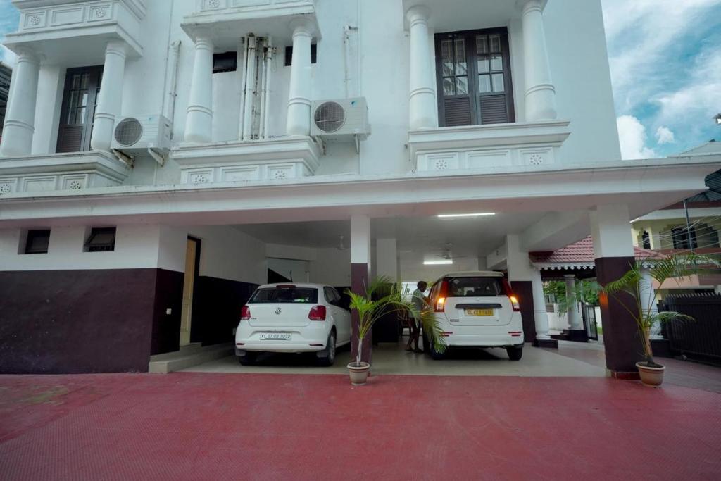 two cars parked in front of a building at Orient Glory Holidays in Edappally
