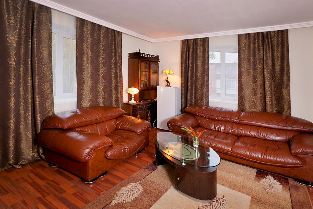 a living room with a leather couch and a table at Yamskaya Inn in Tobolsk