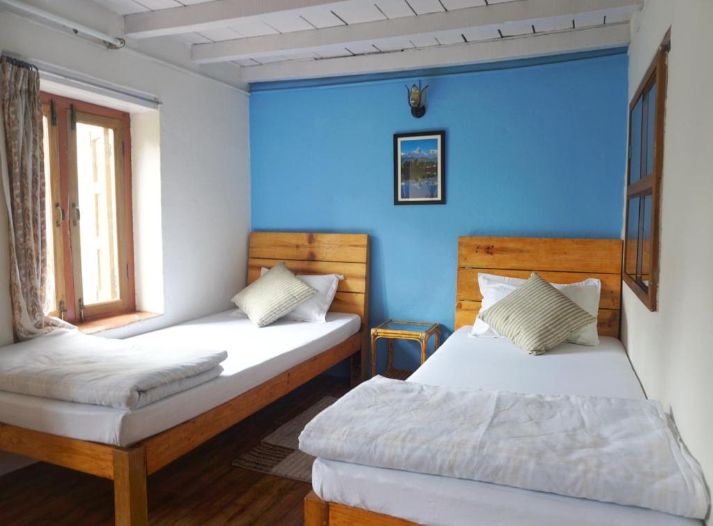 2 letti in una camera con parete blu di Jhigu Homestay Patan a Kathmandu