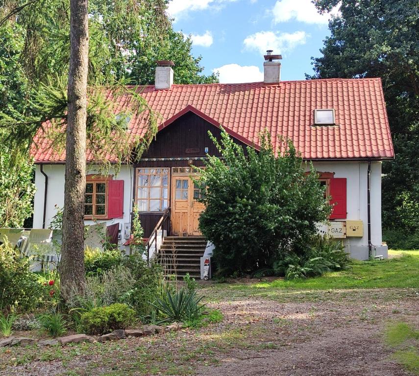 a small house with a red roof at Świętokrzyskie Dworek Radkowice Kasztanowa Aleja in Radkowice