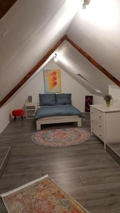 a attic room with a blue bed and a rug at Stilvoll & Wohlfühlfaktor! in Nohfelden