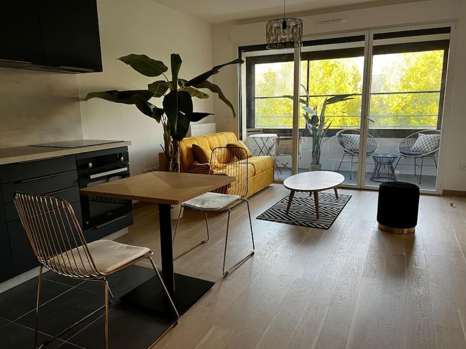 un salon avec un canapé jaune et une table dans l'établissement Disney suite moderne Chessy Parking Gratuit, à Chessy