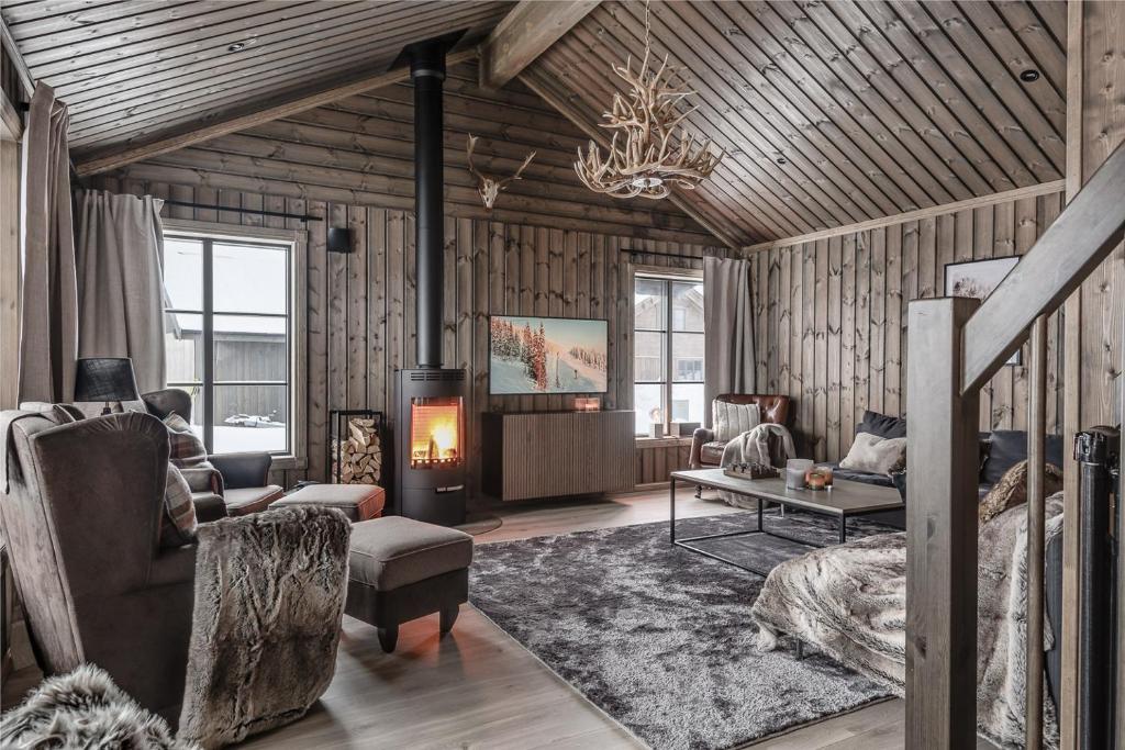 a living room with a fireplace in a log cabin at Lyxig stuga på Branäsberget in Sysslebäck