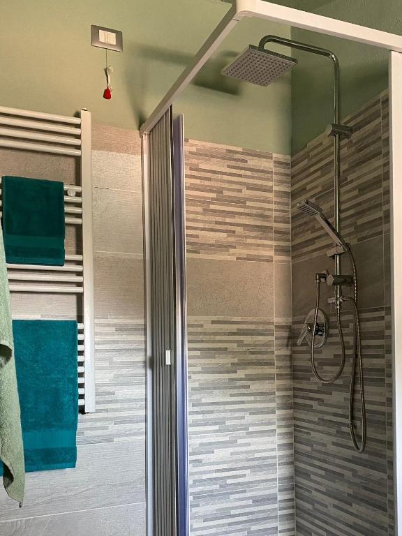 una doccia con una porta in vetro in un bagno di La terrazza nel borgo a Tortora