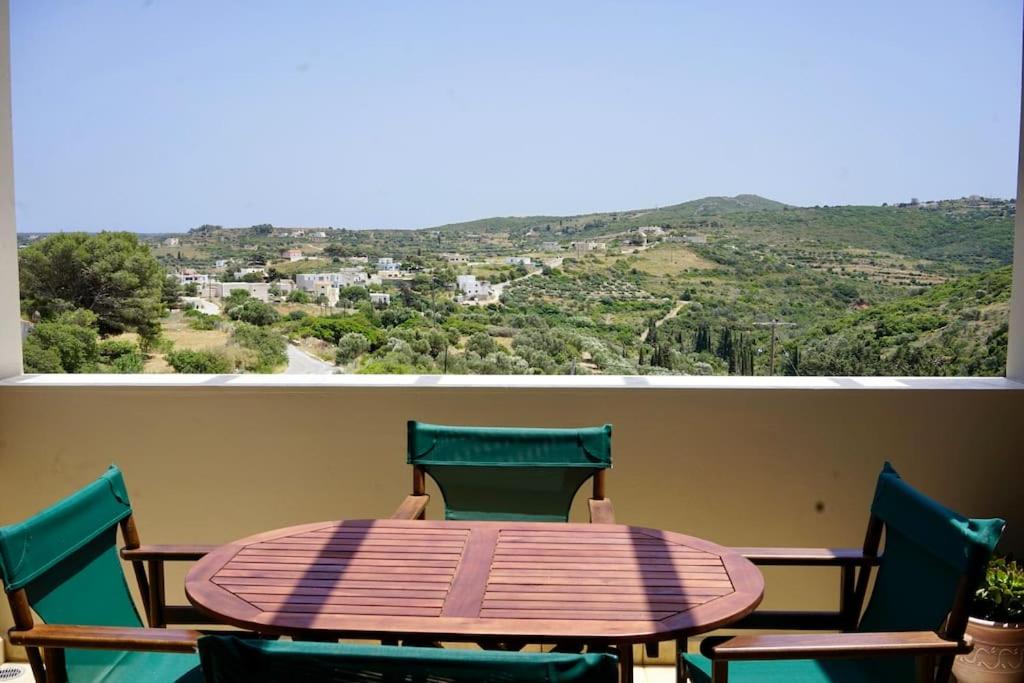 a table and chairs on a balcony with a view at The Baker's Loft in Kýthira