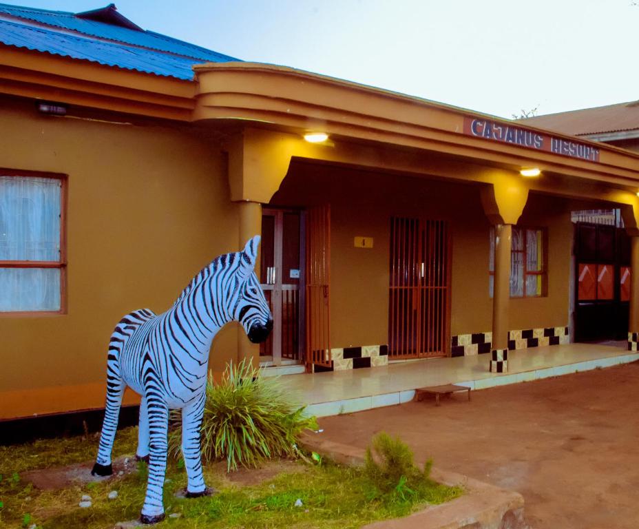 une statue de zèbre debout devant un bâtiment dans l'établissement CAJANUS INN KARATu, à Karatu