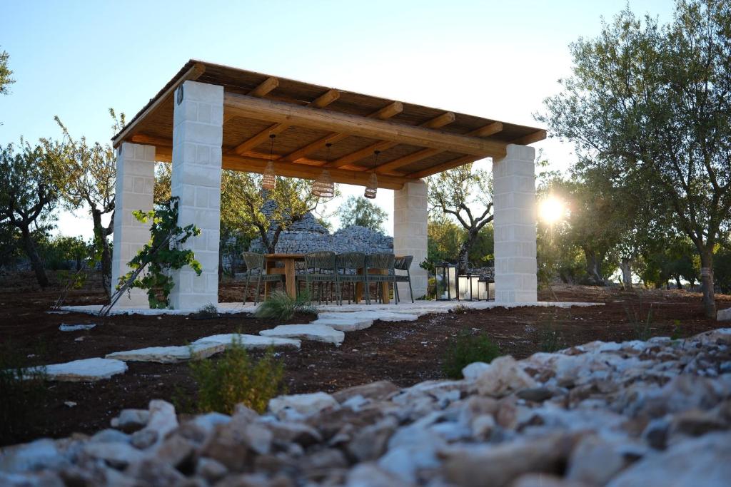 - un pavillon avec une table de pique-nique dans la cour dans l'établissement Borgo dei trulli Fanelli, à Castellana Grotte