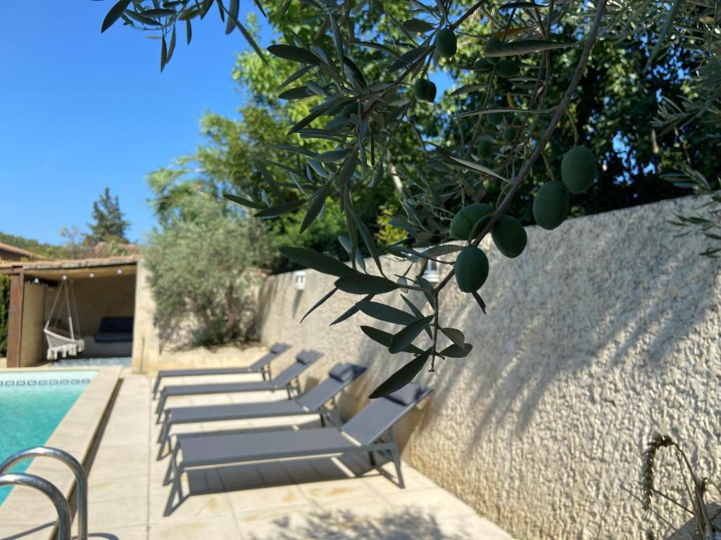 un groupe de chaises longues assises à côté d'une piscine dans l'établissement La maison en couleurs 3 étoiles, avec piscine, à Vedène