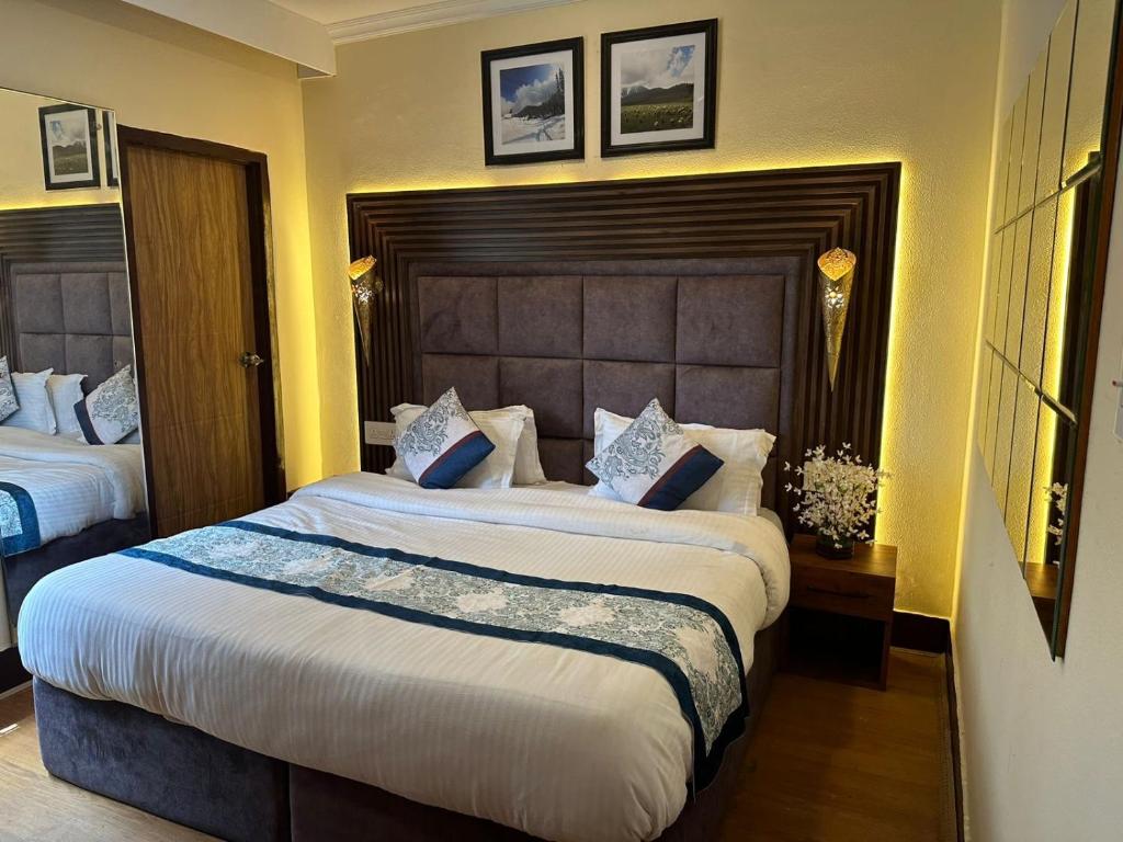 a bedroom with two beds and a large headboard at Srinagar Luxury Escape - Dilan Residency in Srinagar