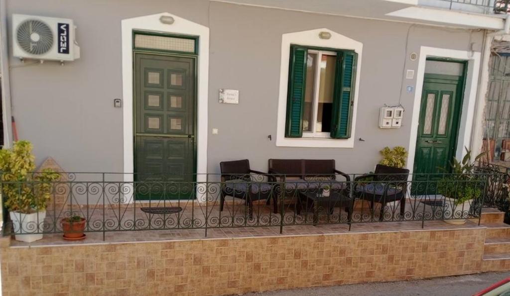 a house with green doors and chairs on a balcony at Anna's House in Vlikhón