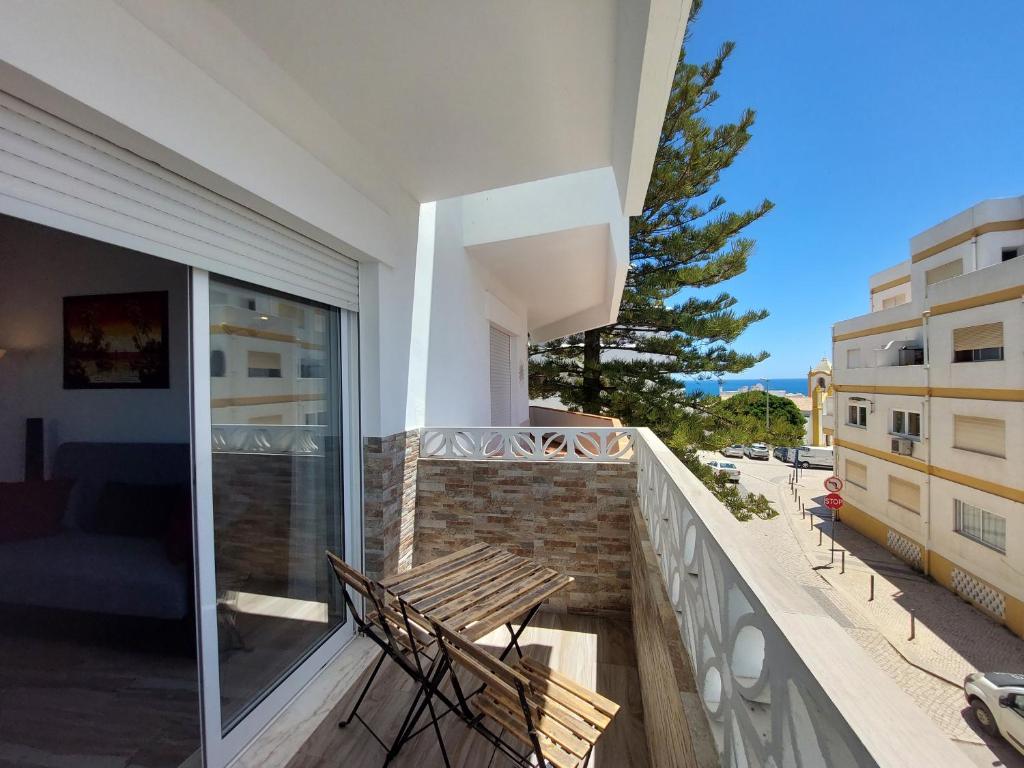 a balcony with two chairs and a view of a building at Sea View 2-beds 'Estrela' Apartment - Praia da Luz in Luz