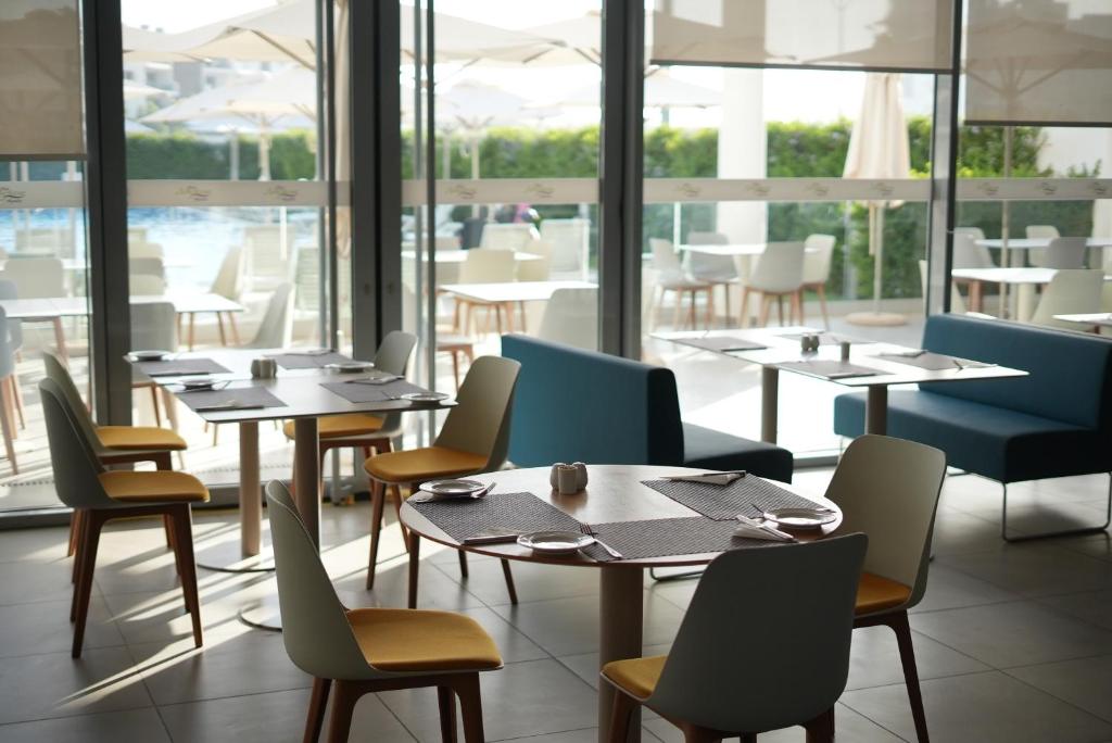 a restaurant with tables and chairs and a large window at Zephyr Agadir in Agadir