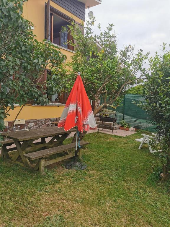 un paraguas rojo sentado sobre una mesa de picnic en Chalet céntrico costero en Gijón, en Gijón
