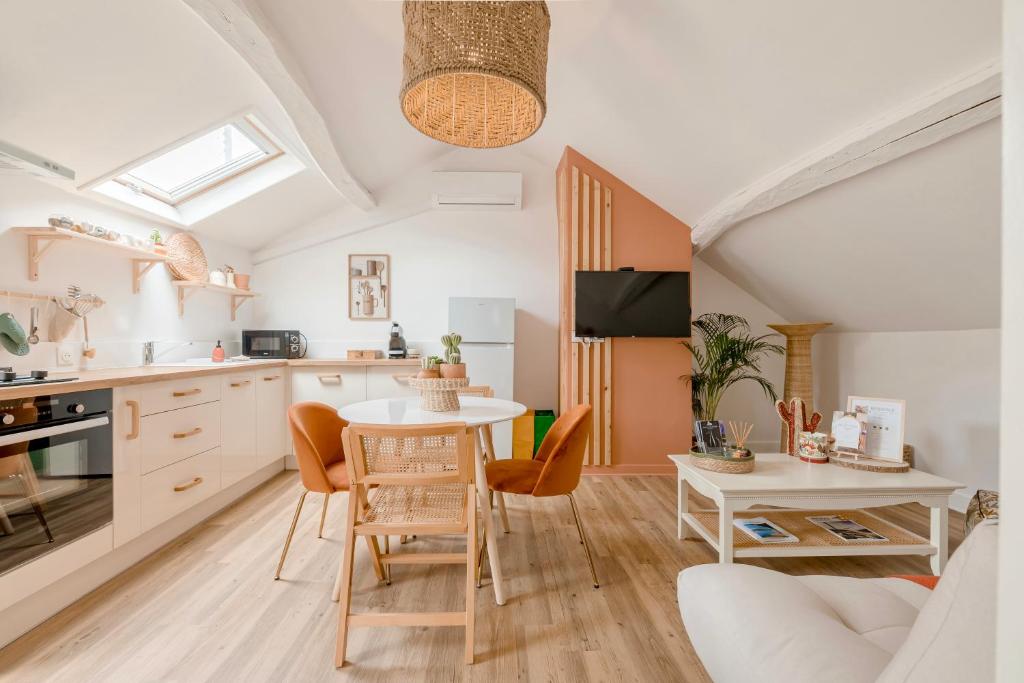 une cuisine et un salon avec une table et des chaises dans l'établissement Charmante Maisonnette, à Montreuil-Bellay