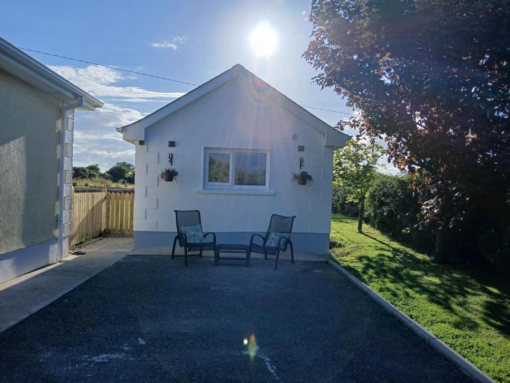 a patio with two chairs and a table in front of a building at Ollie's studio den in Wexford