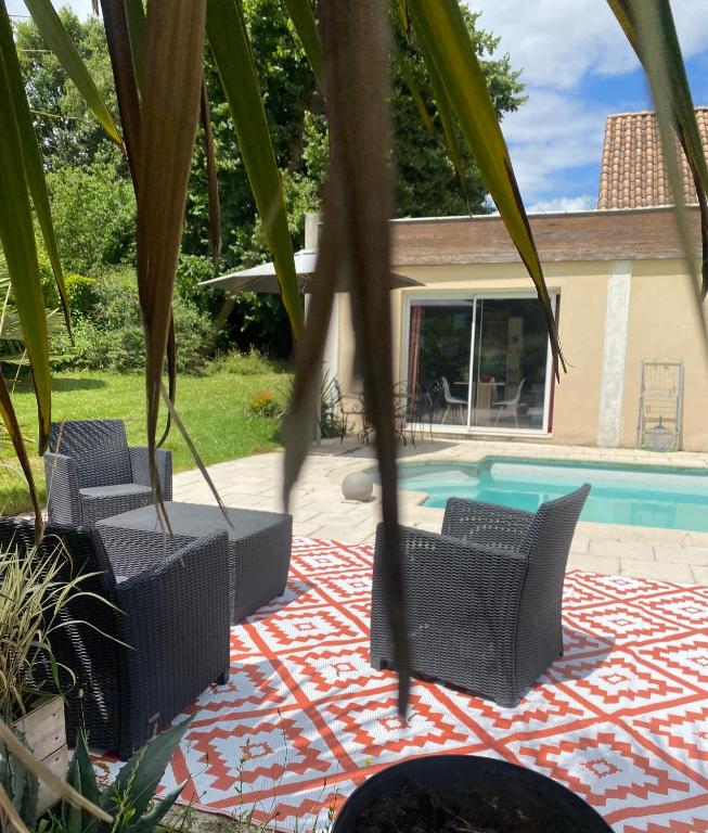 un patio avec des chaises et une piscine dans l'établissement La Butinerie, à Baron