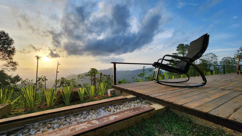 a black chair sitting on a wooden deck at Wildberry Galaha in Kandy