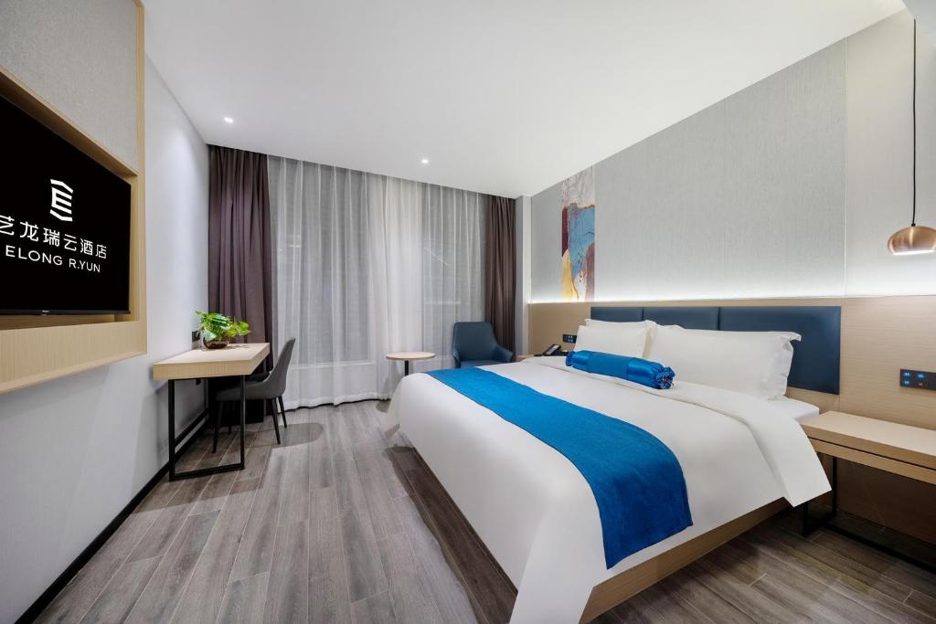 a hotel room with a large bed and a desk at Elong RuiYuan Hotel Hefei Xinhua Garden New Pengbu Road in Hefei