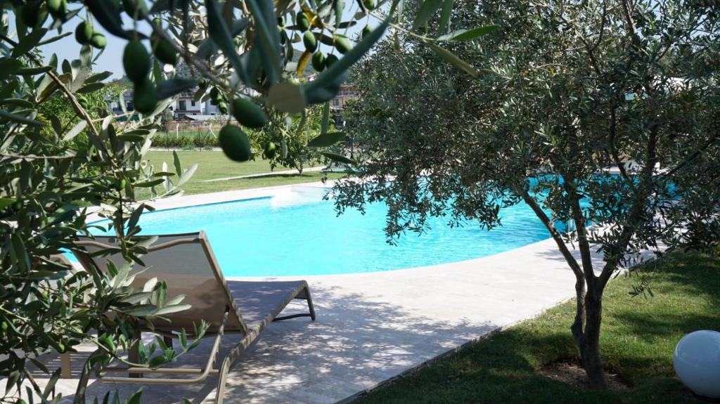a chair and a mirror next to a swimming pool at Muyo House in Urla