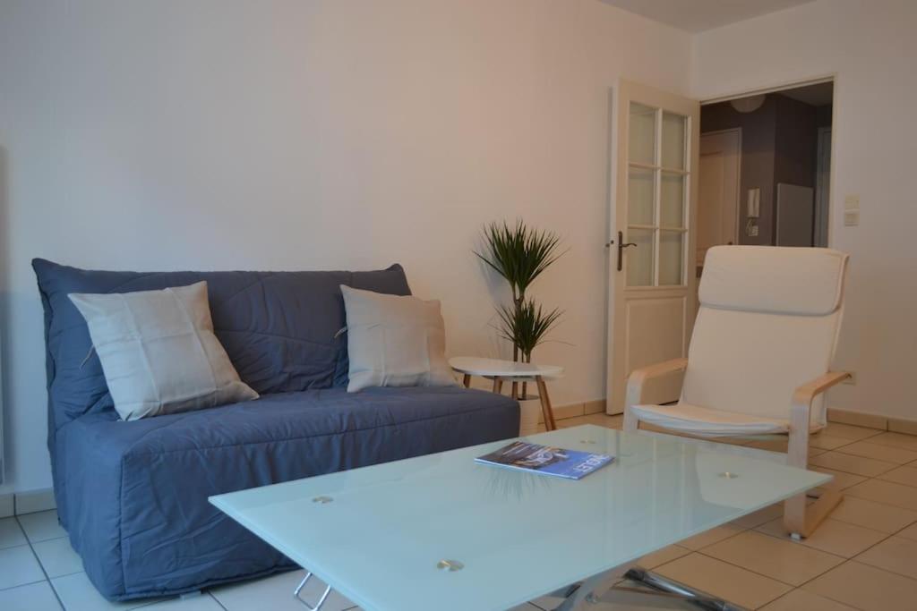 un salon avec un canapé bleu et une chaise dans l'établissement T2 avec terrasse proche commerces et plages, à Anglet