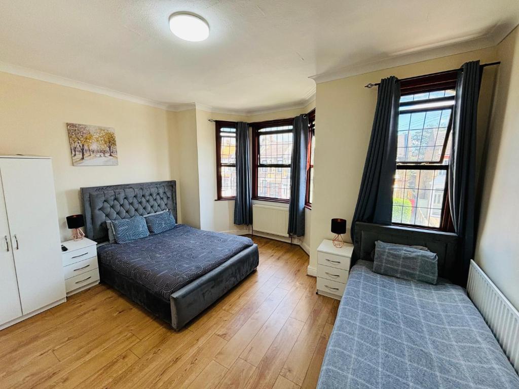 a bedroom with a bed and two windows at Desire Residence in London